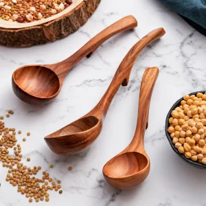 Three ladle spoons with curved handles and back hooks arranged on a marble surface